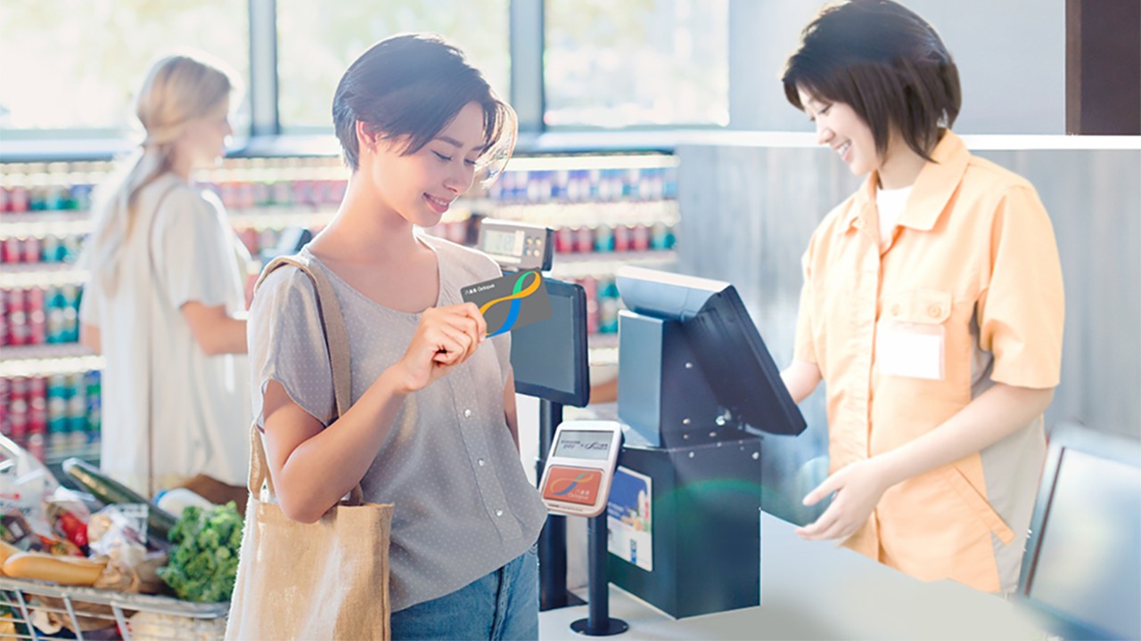一位女士正在使用她的八達通卡付款; 圖片使用於滙豐八達通自動增值服務的頁面。