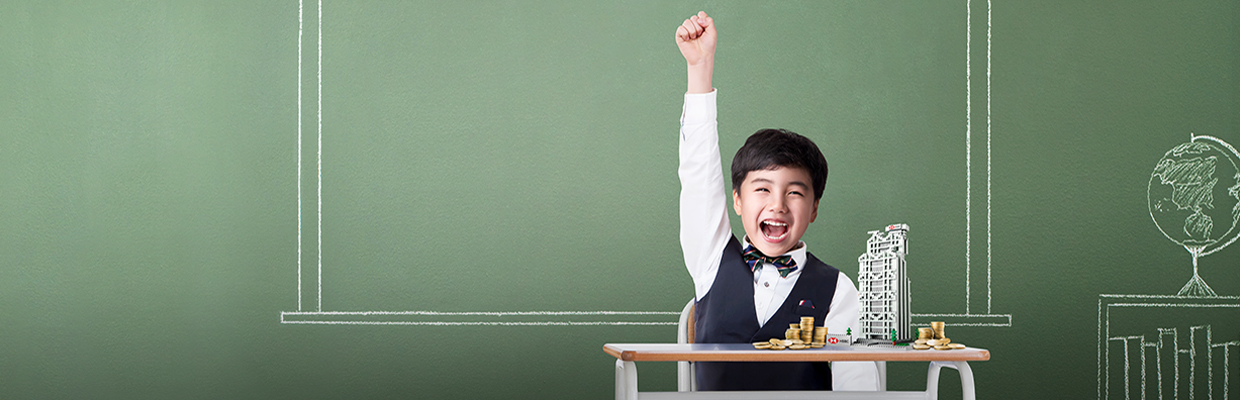 Boy raising his right hand happily with stacked coins and a HSBC building figure in front of him on the table; image used for the HSBC Children Savings Account page. 