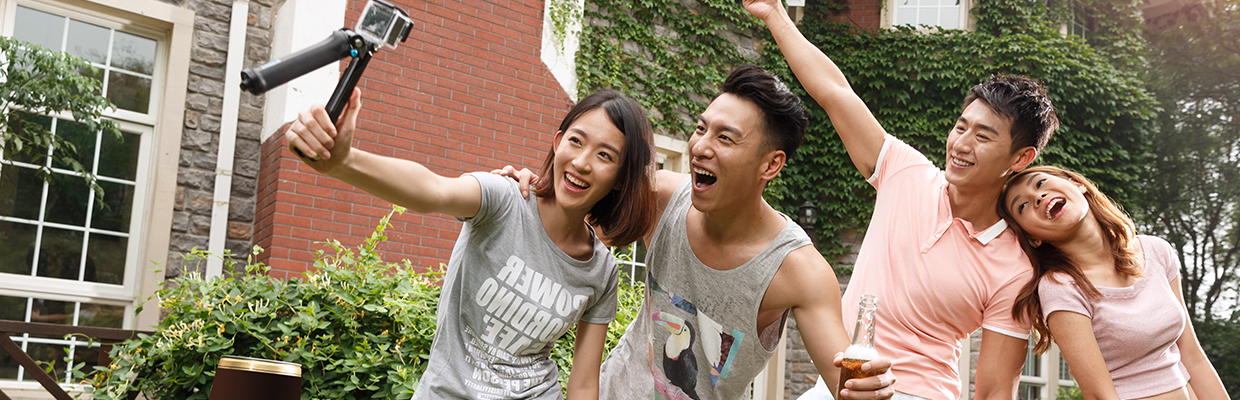 Two couples are taking selfie outside; image used for HSBC Visa Gold Card.