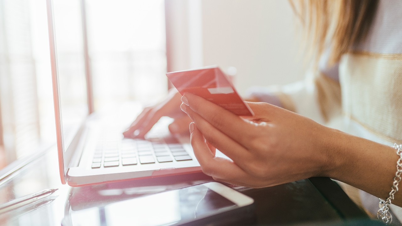 一位女士正在网上购物并使用她的信用卡付款；图片使用于汇丰Red 信用卡赚尽网上签账优惠。