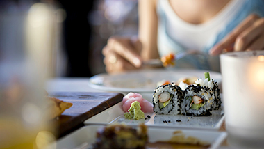 一位女士正在吃日本料理；图片使用于汇丰最新优惠网页面。
