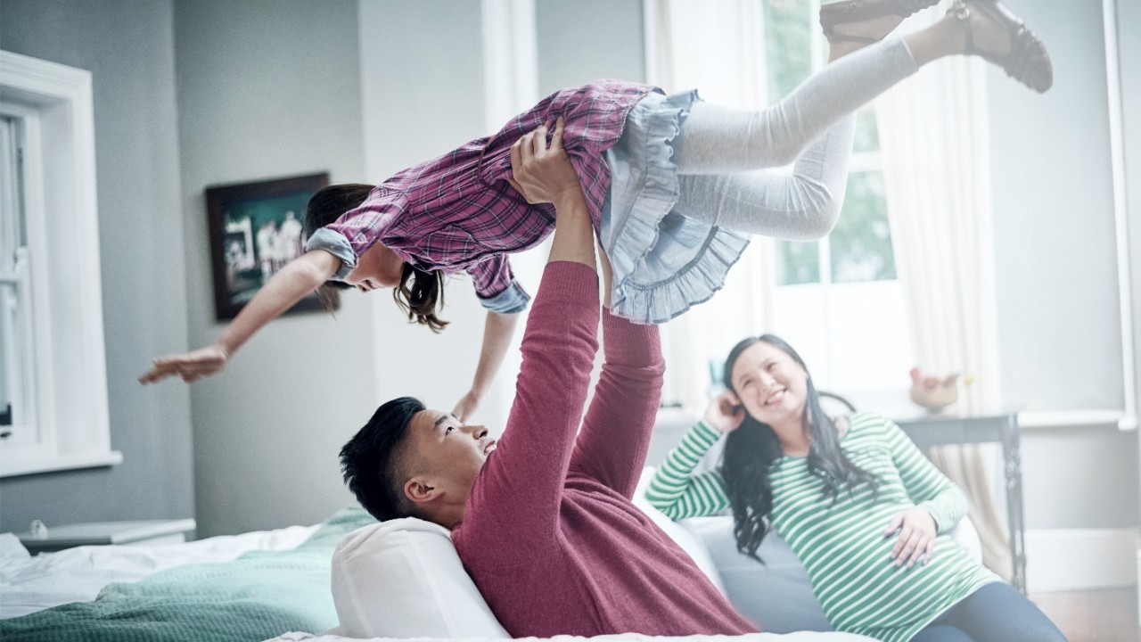 Father hold up daughter; image used for Mortgage Protection Insurance.