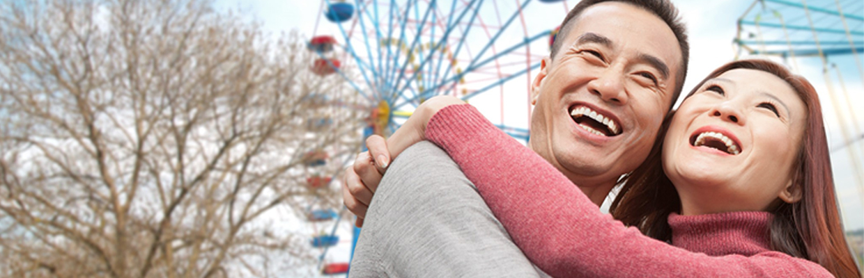 一对情侣在摩天轮下拥抱；图片使用于滙豐盈達年金計劃页面。