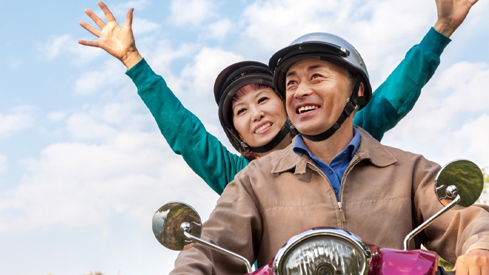 一对年迈夫妇兴奋地骑着摩托车；图片使用于汇丰盈达延期年金计划页面。