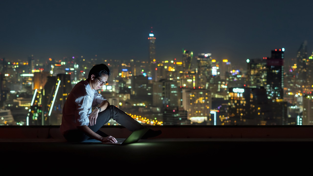 A man using the laptop over the cityscape background