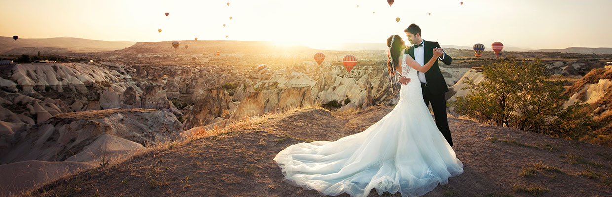 A couple is wearing their wedding dress and dancing in the mountain, image used for "Destination wedding planning" article   