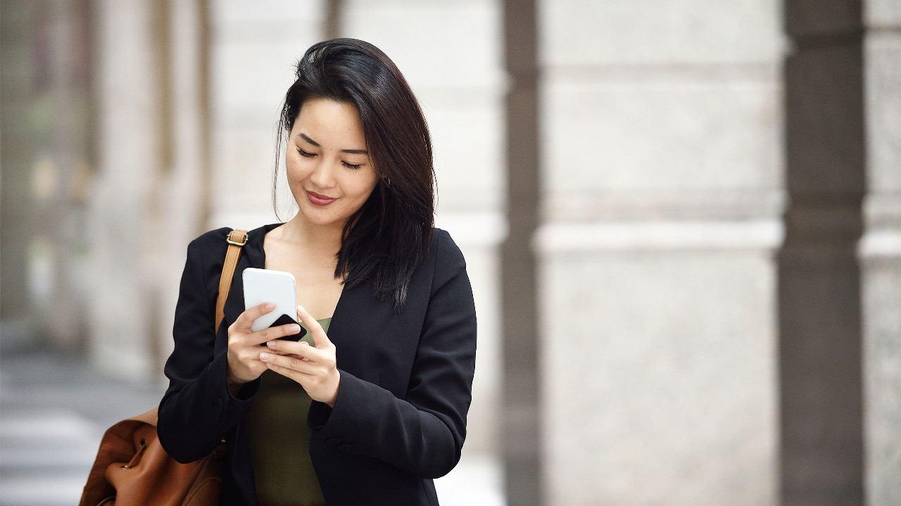 Woman using her mobile phone; image used for HSBC reward+ mobile app.