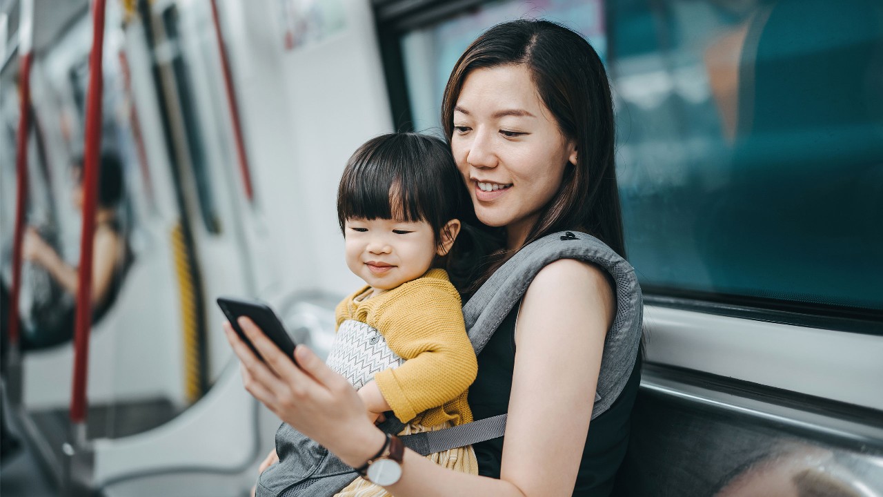 女人和儿子在地铁看手机；图片用于以报失信用卡