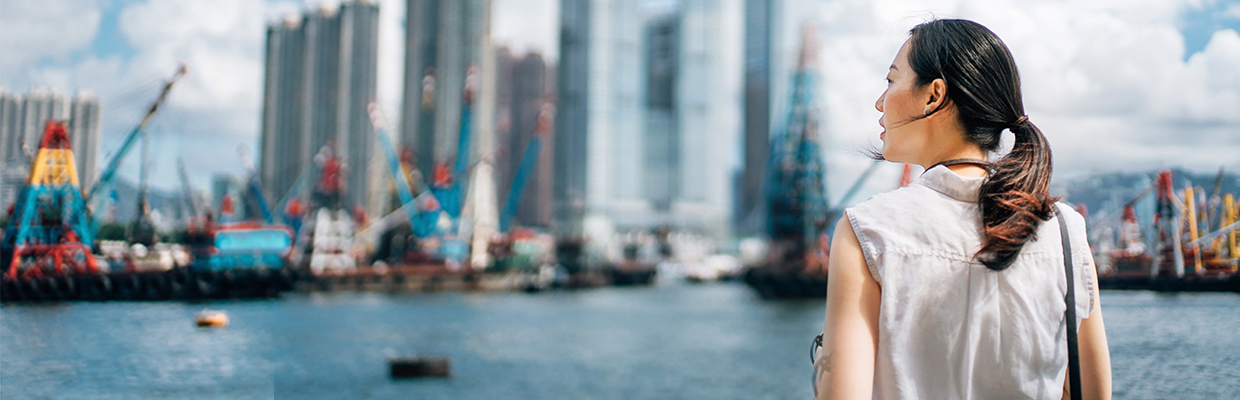 女士正在俯瞰城市景觀；圖片使用於香港本地銀行服務。