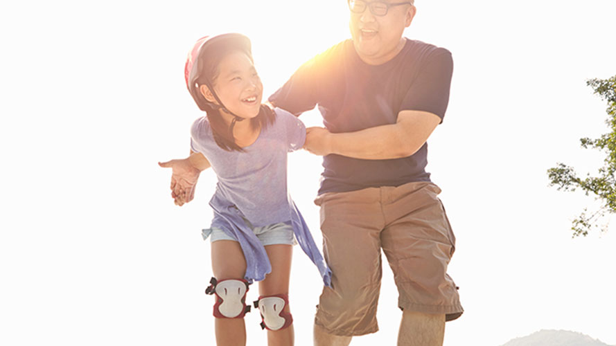 父亲在协助女儿一起玩滚轴溜冰；图片使用于汇丰協助及支援页面。
