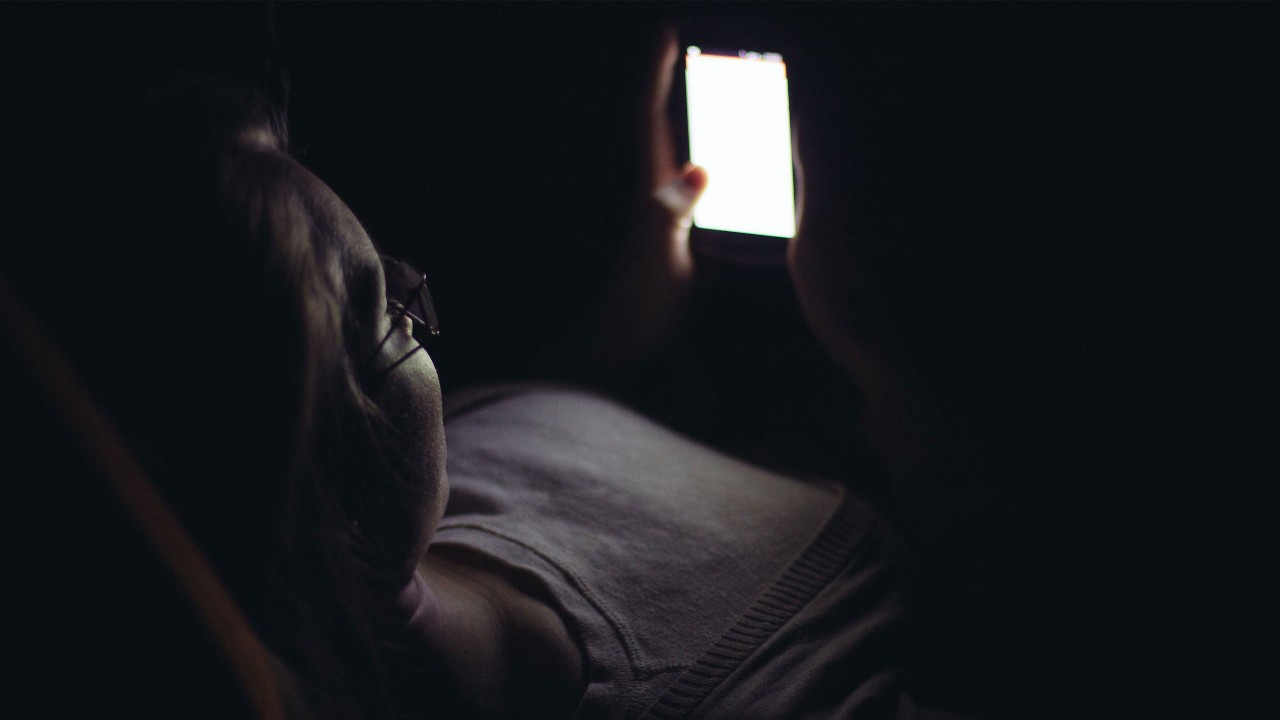 一个女人在夜晚使用她的智能手机；