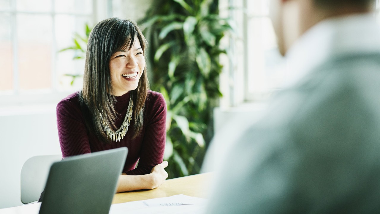 a smiling  women in a meeting ; image used for HSBC Wealth Portfolio Plus