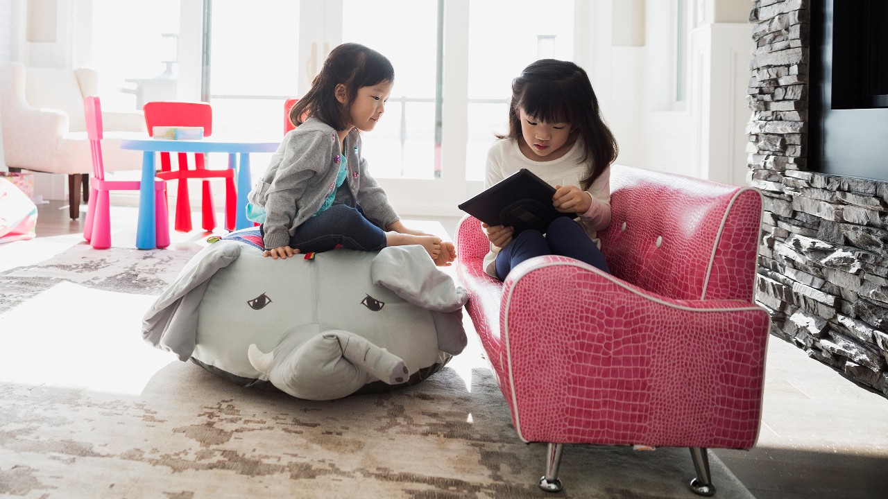 Sisters using digital tablet in playroom; image used for HSBC online and banking security.