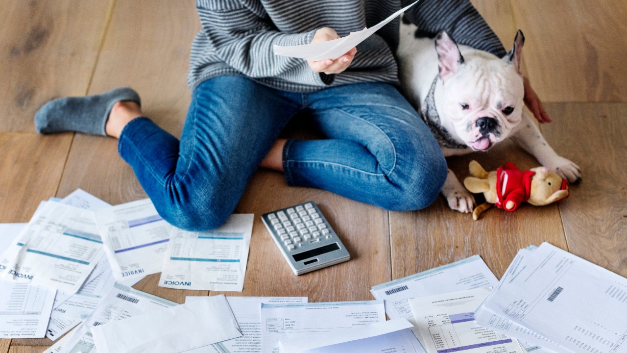A lady is checking her bills while holding her puppy; image used for HSBC Bill Payments