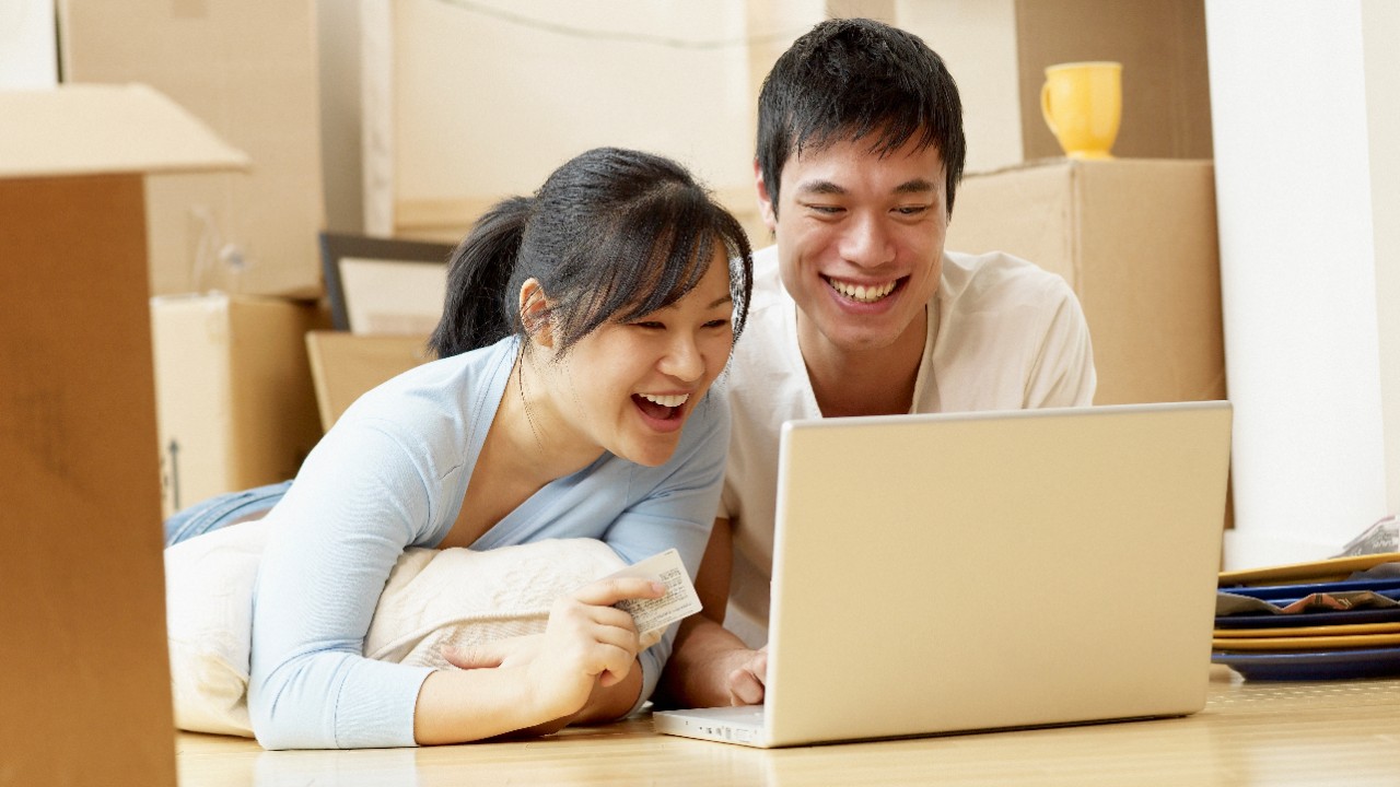 一對情侶正在用筆記本電腦進行網上銀行轉帳；圖片使用於滙豐環球轉賬。